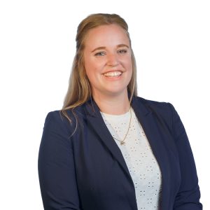 Portretfoto van een lachende vrouw in een donkerblazer, gemaakt tijdens een bedrijfsevent van Makker Hoortoestellen.