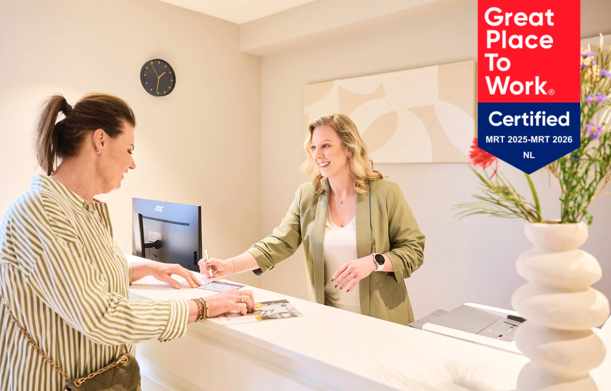 Frontoffice-medewerker van Makker Hoortoestellen helpt een klant bij de receptie.