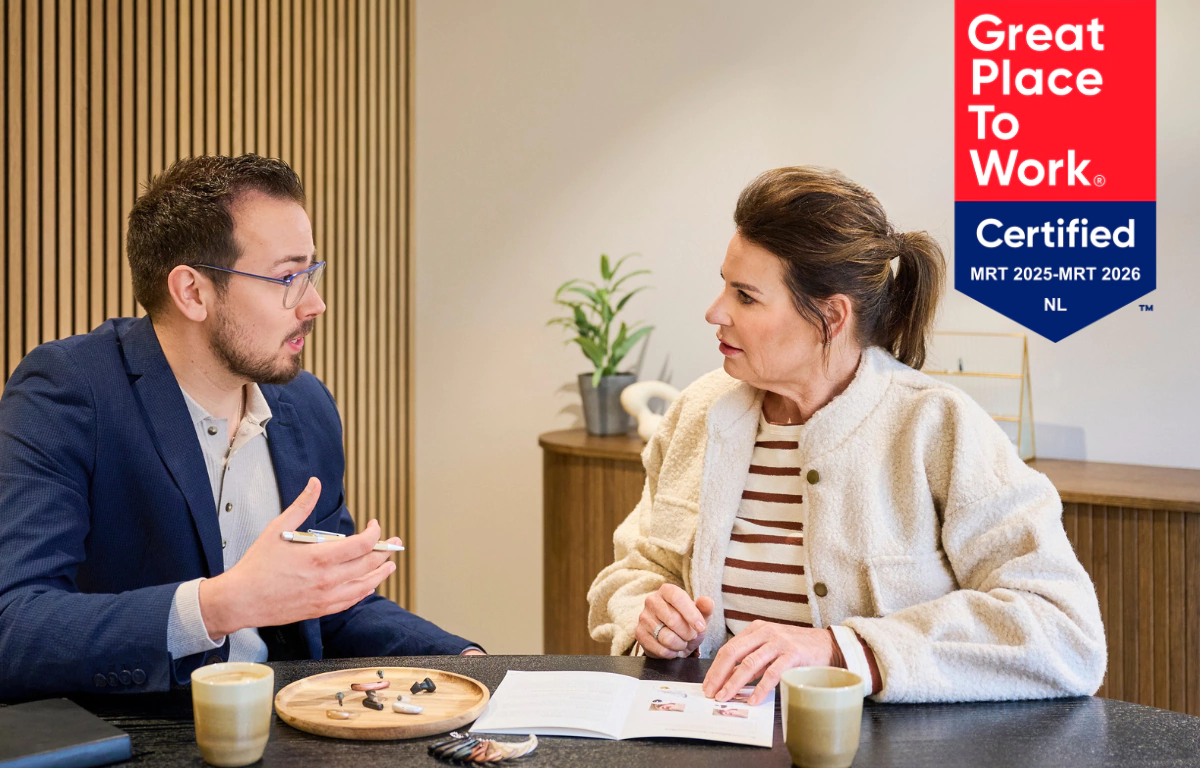 Audicien in gesprek met klant over hoortoestellen bij Makker Hoortoestellen.