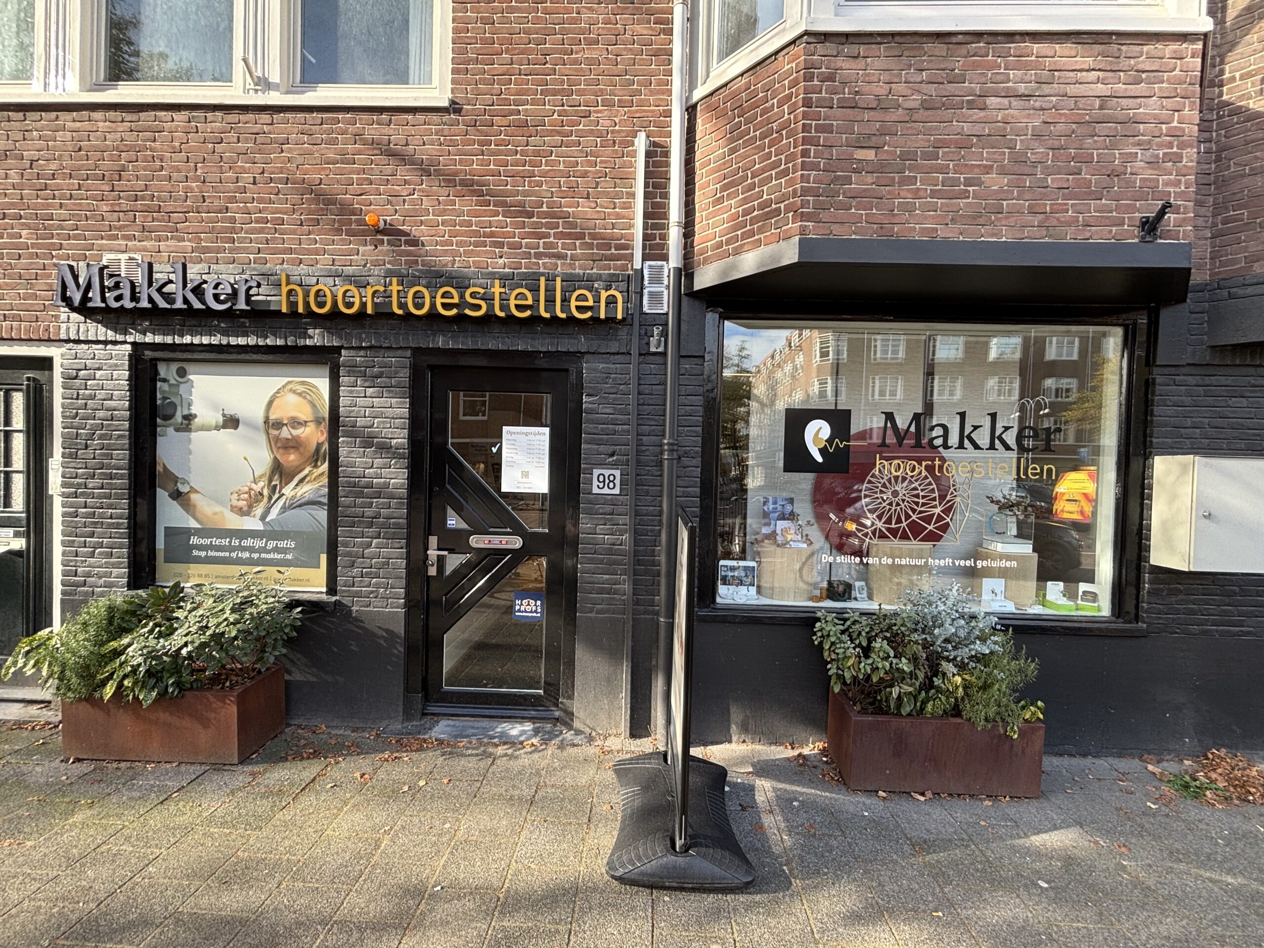 vooraanzicht van een makkerwinkel , met een reclame poster van een blonde vrouw
