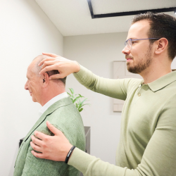 Audicien helpt klant met hoortoestel