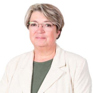 Portret van een vrouw met kort grijs haar en bril, in een lichte blazer en groene top.